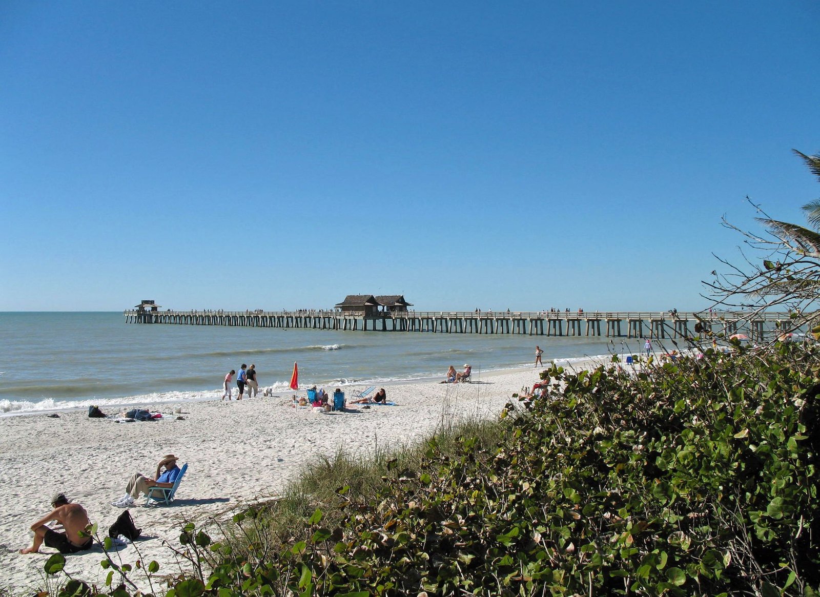 Naples Pier and beach on a sunny day in Naples, Florida