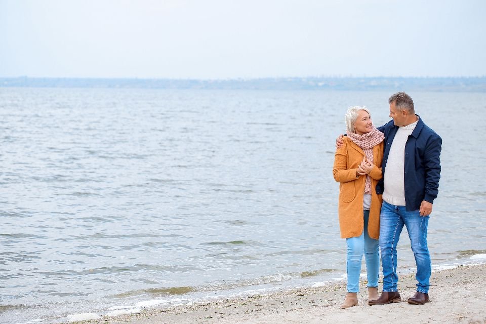 Couple walking along the beach after relocating to Florida